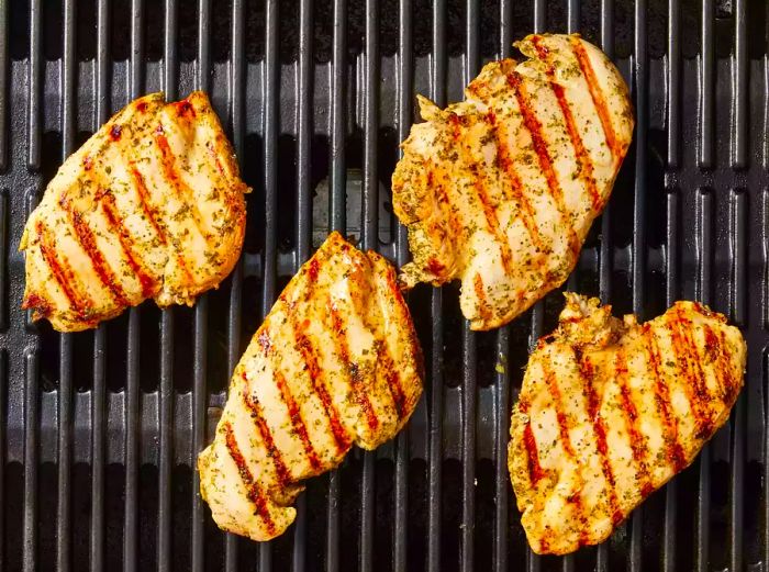 Juicy grilled chicken breasts sizzling on the grill