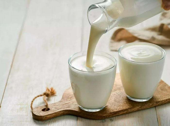 Pouring homemade buttermilk into a glass