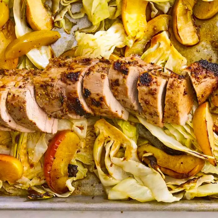 Close-up shot of sliced Dijon Pork with Apples and Cabbage resting on a baking sheet