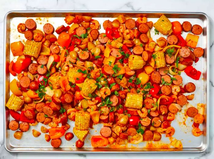 A shrimp and sausage bake garnished with freshly chopped parsley and green onions.