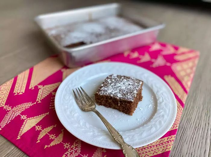 Slice of waste-not cake topped with powdered sugar