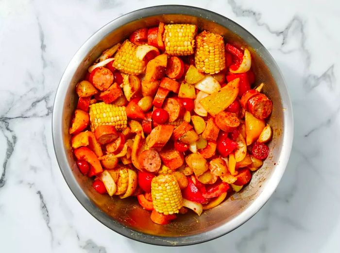 The seasoning mixture is added to the corn and sausage, then thoroughly stirred in.