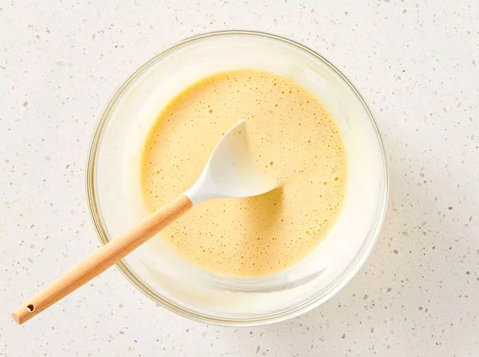 A glass bowl filled with beer batter