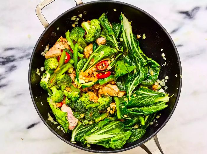 A wok with a delicious stir fry of pork and vegetables