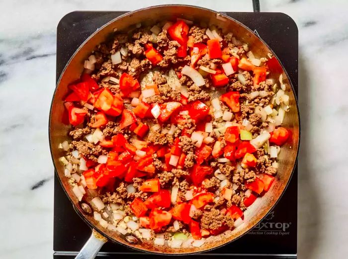 Ground beef and vegetables sizzling in a skillet