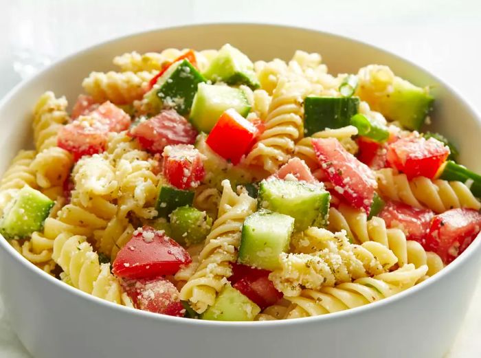 A mid-angle view of a large bowl filled with pasta salad.