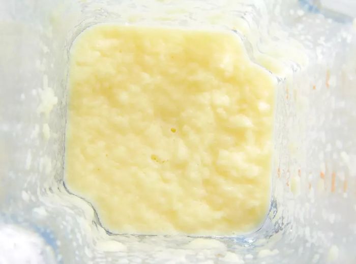 Close-up view of a blender filled with a pale yellow mixture