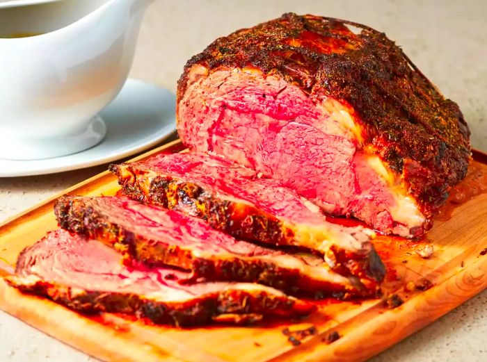 Sliced prime rib from the Christmas roast, displayed on a wooden cutting board.