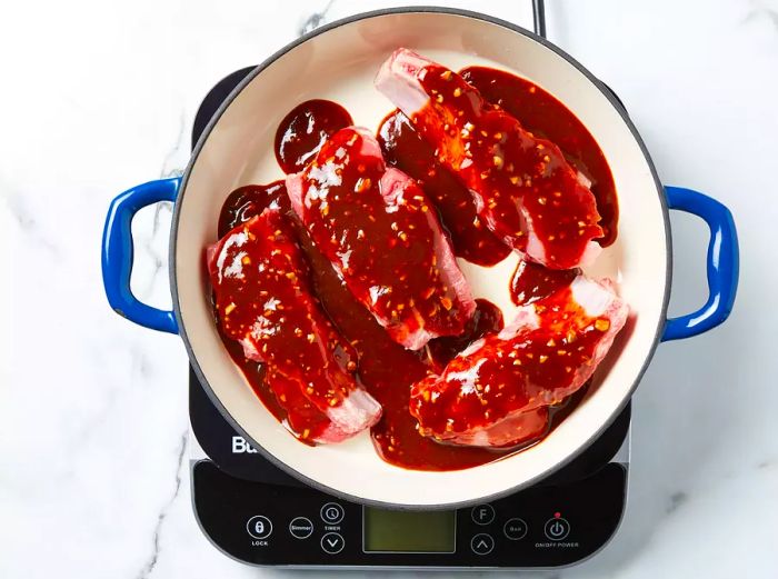 Place the ribs in the stockpot and cover them with the sauce.