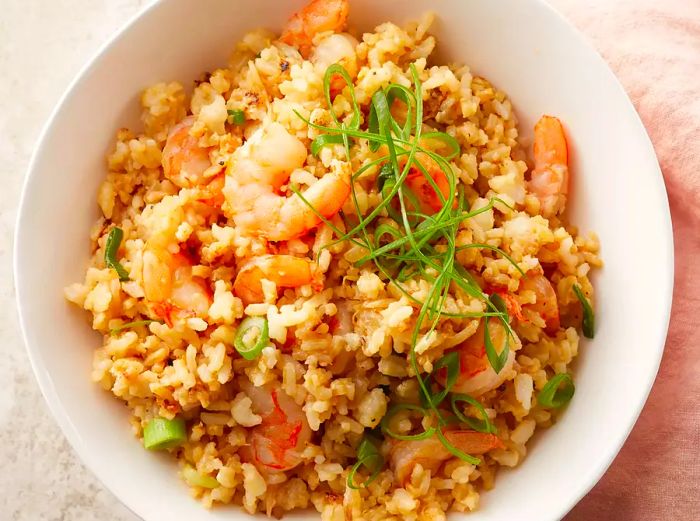 A top view of a bowl of freshly made shrimp fried rice.