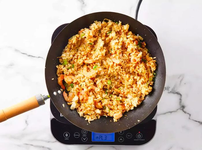 The remaining ingredients are added to the wok and cooked until everything is well combined.