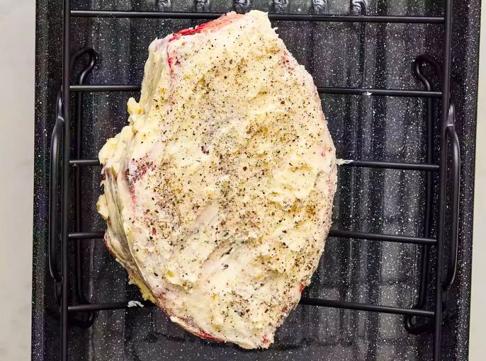 The roast, coated with the butter mixture, is now ready in the roasting pan.