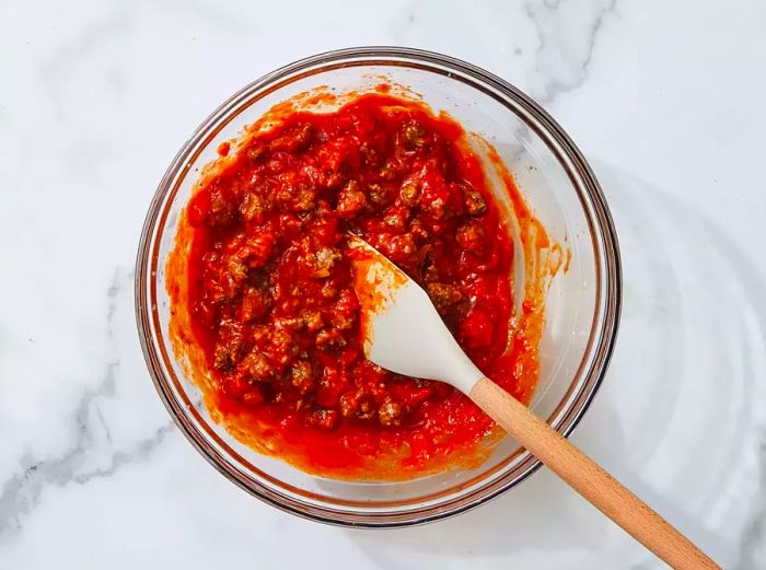 Beef combined with spaghetti sauce in a bowl