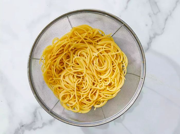 Spaghetti noodles draining in a colander