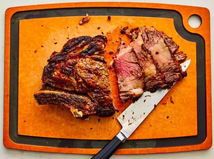 The roast is sliced and placed on a cutting board.