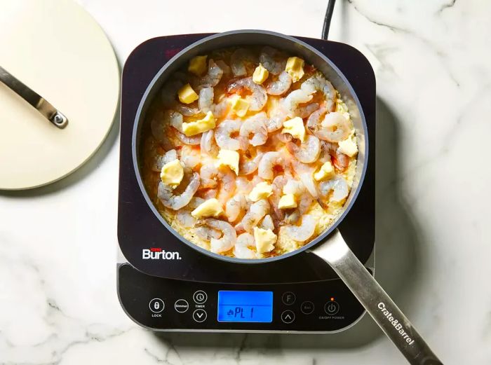 Rice, shrimp, and butter added to the skillet.