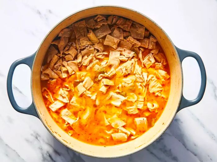 A large pot filled with chopped chitterlings in a flavorful broth.