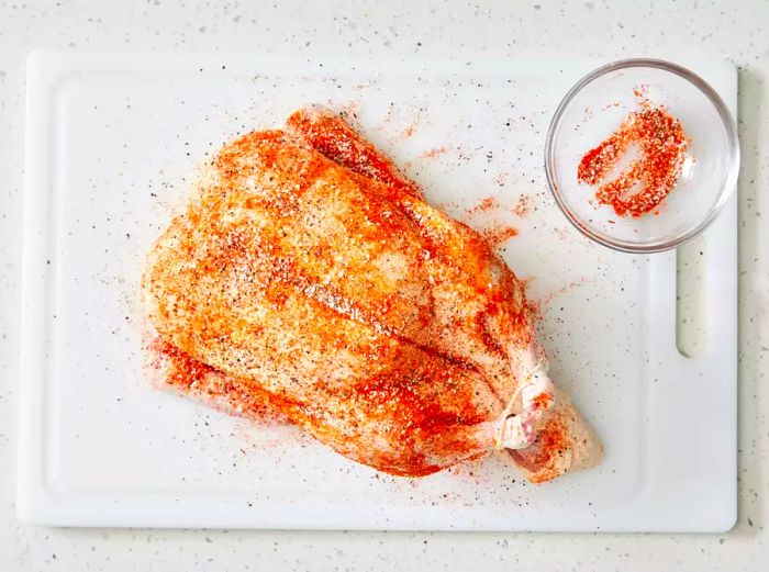 A whole duck seasoned with salt, pepper, and paprika