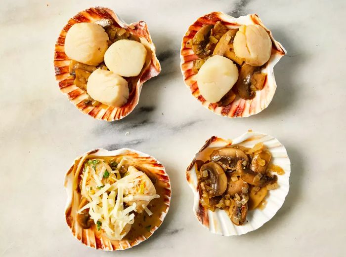 Four scallop shells filled with cooked mushrooms, scallops, and grated cheese