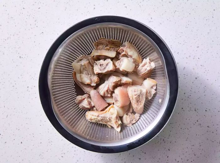 A colander filled with boiled pig tails