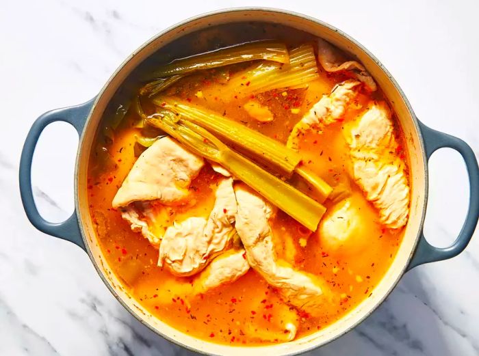 A large pot of simmered chitterlings with celery, onion, and seasonings.