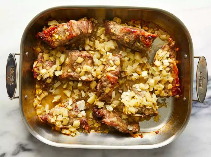 Golden-brown neck bones resting in the roasting pan after they’ve finished baking.