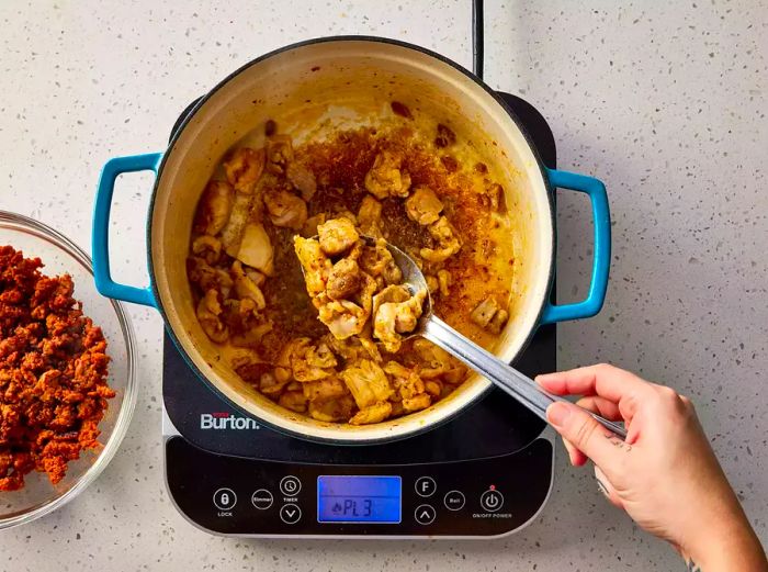 Chicken pieces browning in the Dutch oven.