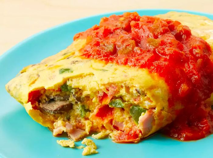 Close-up view of a cooked omelet in a bag, topped with a dollop of salsa.