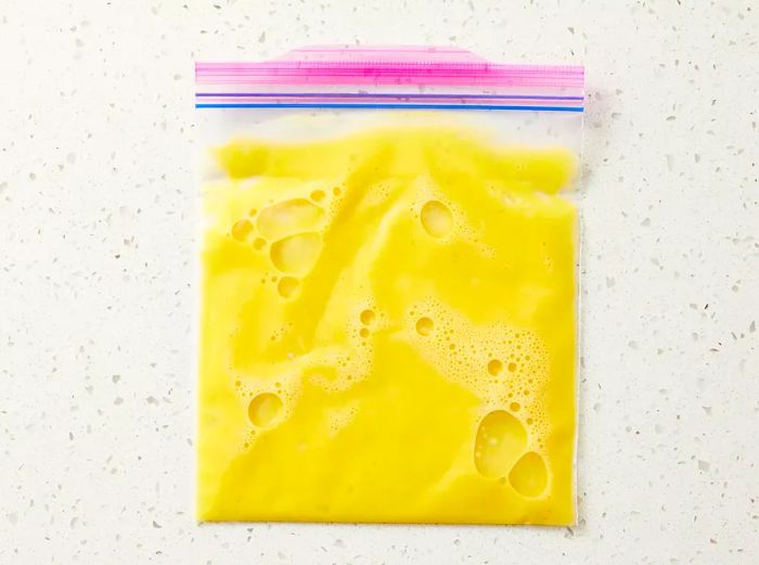 Eggs cracked and mixed inside a large resealable bag, ready to cook.