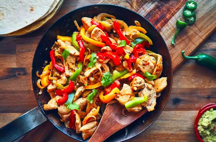 A sizzling skillet of chicken fajitas.