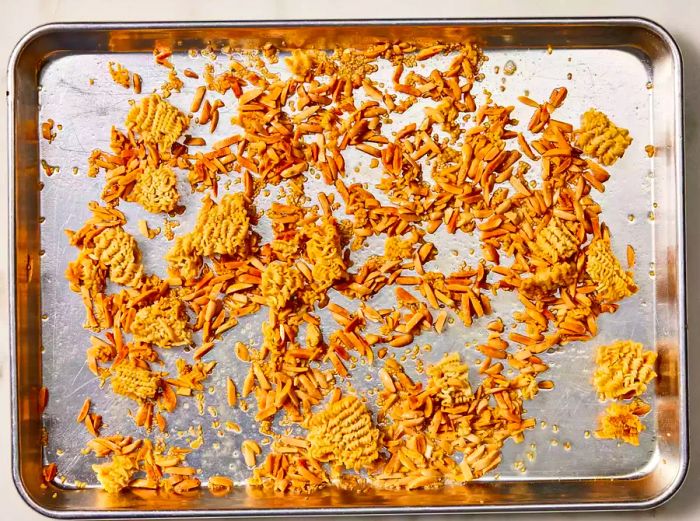 A tray of toasted ramen noodles and almonds cooling after roasting in the oven.