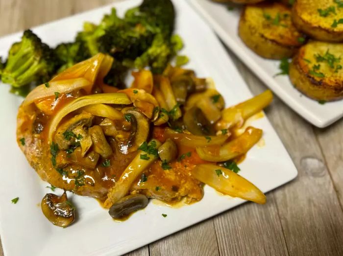 Pork chops served with a mushroom topping and a side of broccoli