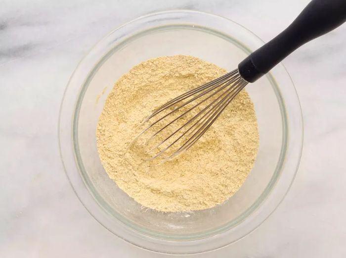 A small bowl of mixed spices with a whisk