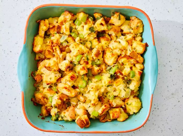 A baking dish filled with golden, baked gluten-free Thanksgiving stuffing