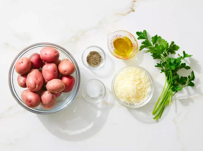 All the ingredients needed for crispy smashed potatoes neatly arranged on a kitchen counter.