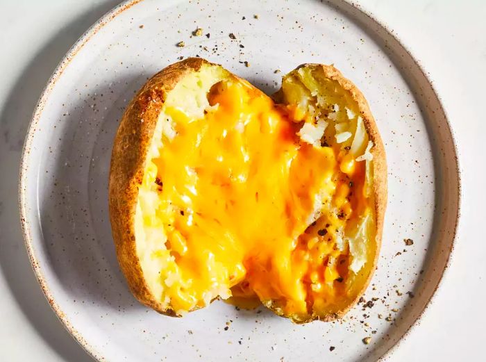 A microwave-baked potato topped with gooey cheddar cheese.