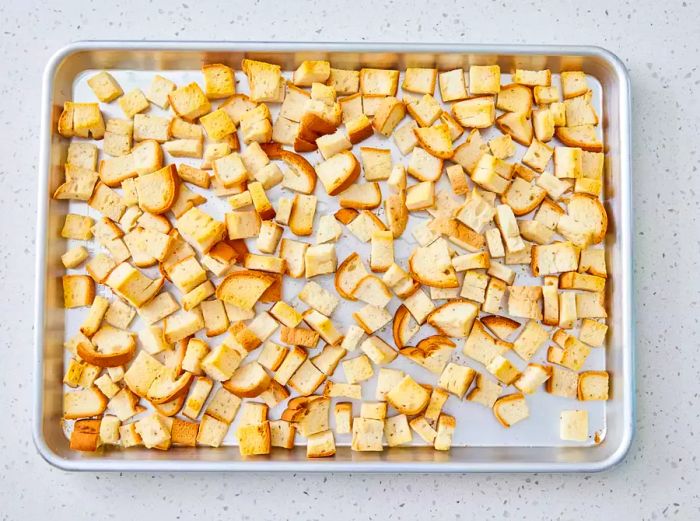 A baking sheet with golden, crispy cubes of gluten-free bread