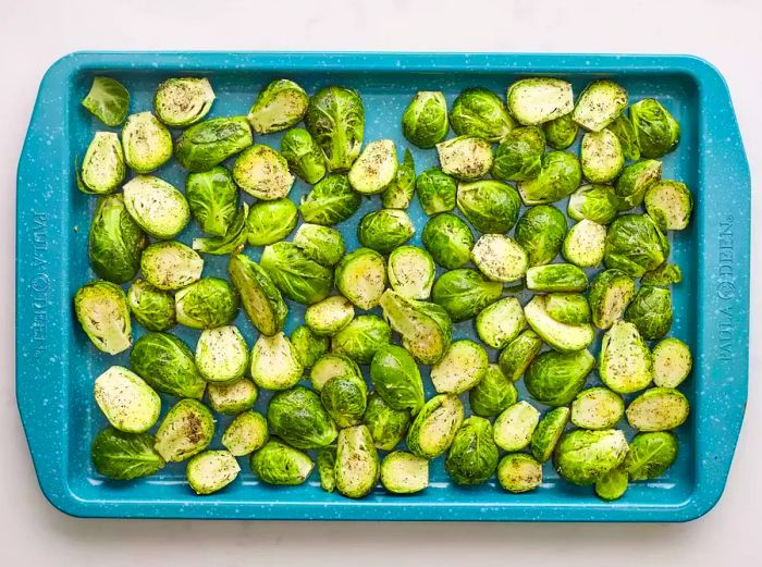 Fresh Brussels Sprouts arranged in a blue baking dish