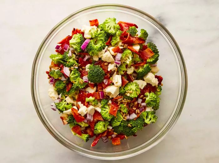 A large bowl filled with a mix of vegetables and crispy bacon.