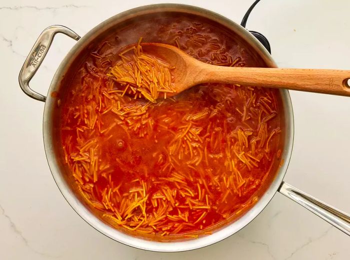 A skillet of fideo pasta cooked in rich tomato sauce