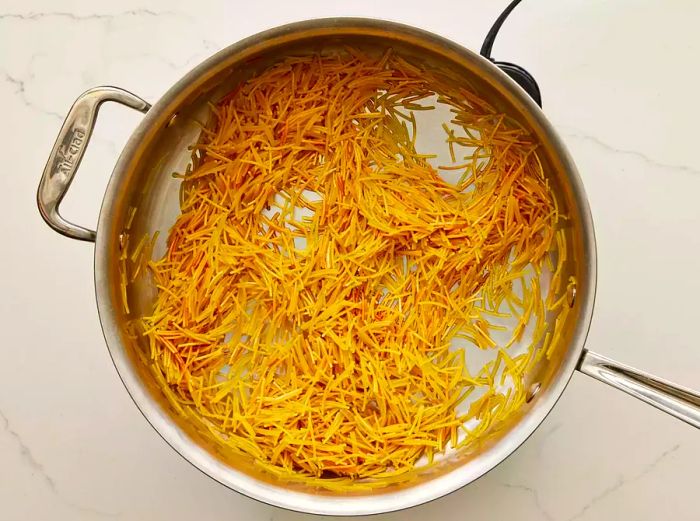 A large skillet filled with perfectly toasted Fideo pasta