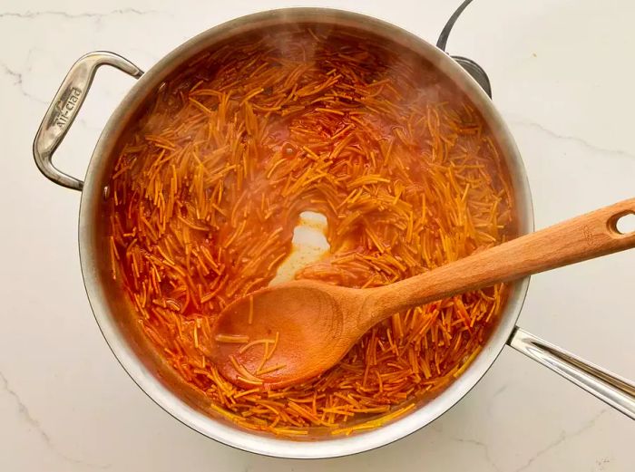 A pot of fideo pasta simmering in tomato sauce