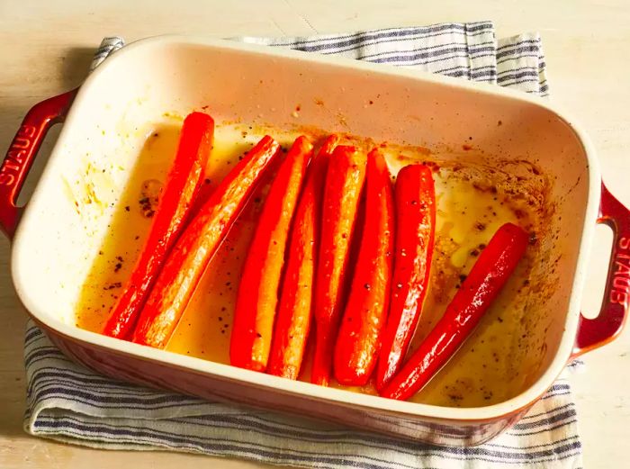 A top-down view of a baking dish filled with honey roasted carrots.