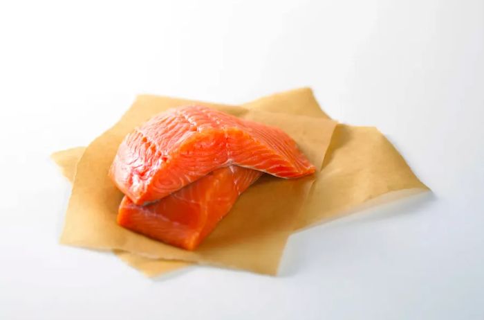 Salmon fillets placed on parchment paper