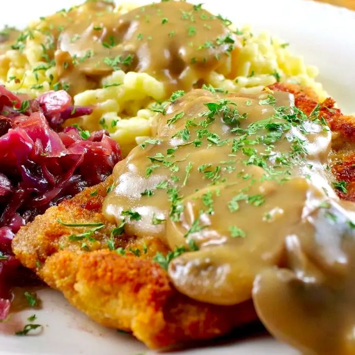 Hunter’s Schnitzel served with rich gravy, creamy mashed potatoes, and tangy red cabbage