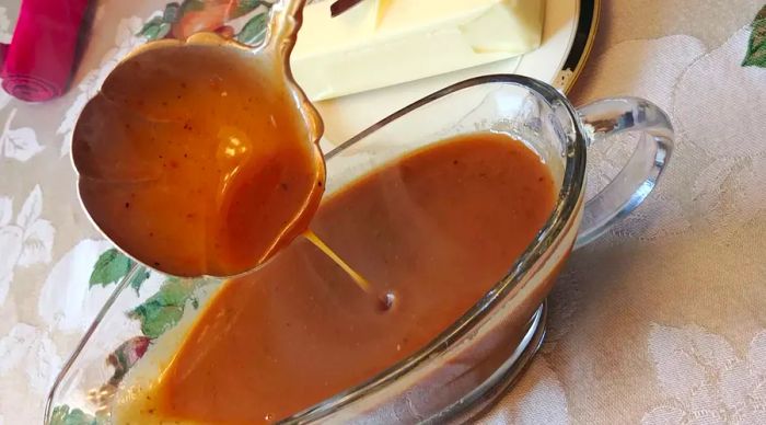 rich, brown gravy served in a gravy boat with a ladle