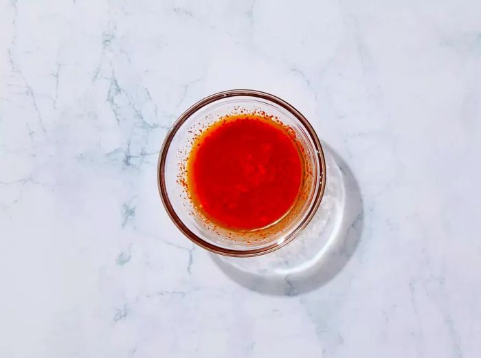 A small glass bowl filled with spicy garlic sauce