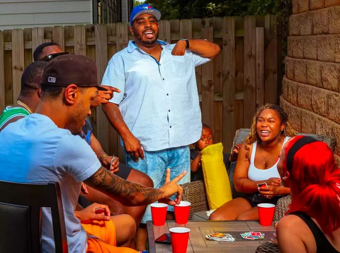 Dakari’s friends and family gathered around a table, enjoying card games together.