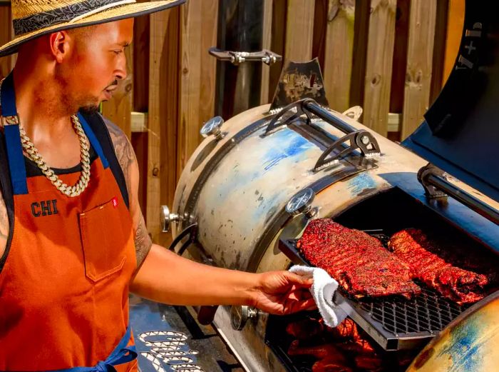 Dakari Akorede watching over some ribs on his custom grill in his backyard just outside of Atlanta.