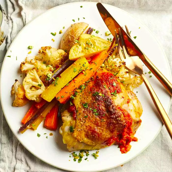 A top-down view of a plate showcasing a serving of harissa chicken sheet pan dinner